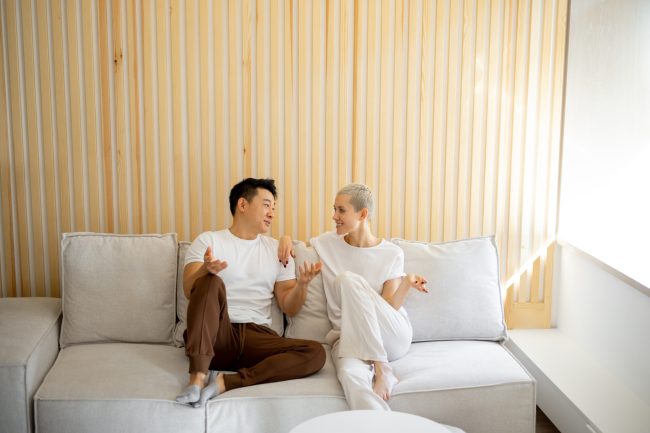 Multiracial,Couple,Sit,And,Rest,On,Sofa,At,Home.,Concept